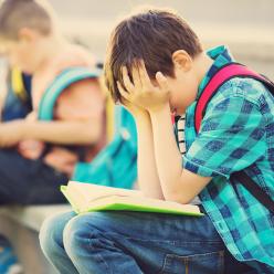 Boy sitting on steps with head in his hands