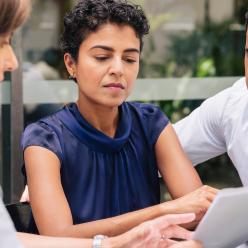 Couple discussing paperwork with woman