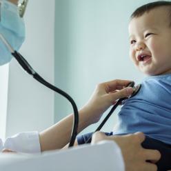 Doctor examines a smiling baby