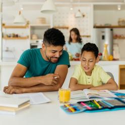 A father is helping his child with homework