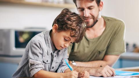 Man helping boy with his homework