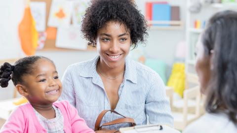 Mother and daughter talking to a teacher