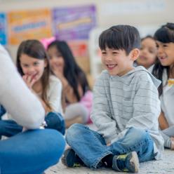 Boy sitting on the floor with class and smiling