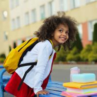 Smiling preschooler wearing a backpack