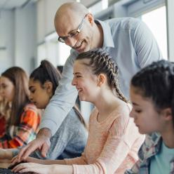 Teacher is helping students at computers