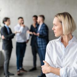 Woman standing apart from a crowd of coworkers