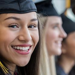 Smiling young woman in a cap and gown